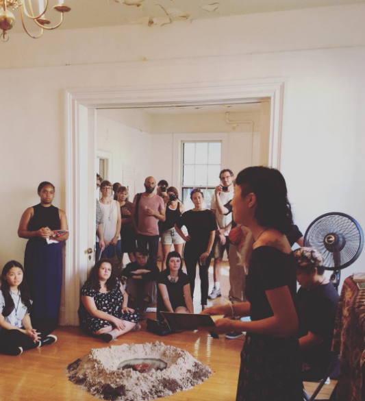 Jess X Snow performing a poem at the opening of Exploring Human Injustices through Art Angry Indian Mask, 2016 by Jorge Alberto Perez